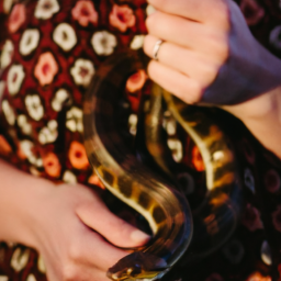 description: an anonymous image shows a woman confidently holding a venomous snake.