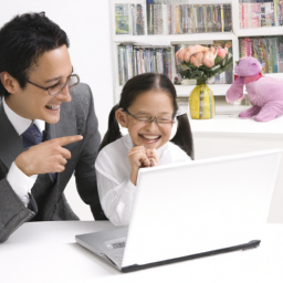 a parent and child sitting at a desk, looking at a laptop and smiling.