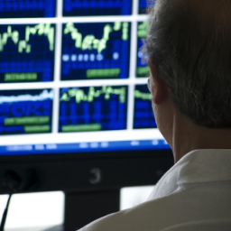 An image of a person looking at a computer screen with stock market information.