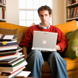 description: a photograph of a person sitting on a couch with a laptop, surrounded by books and papers, looking focused and determined.