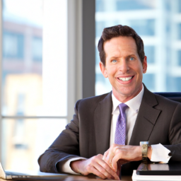 A smiling financial advisor sits at a desk in a professional office.